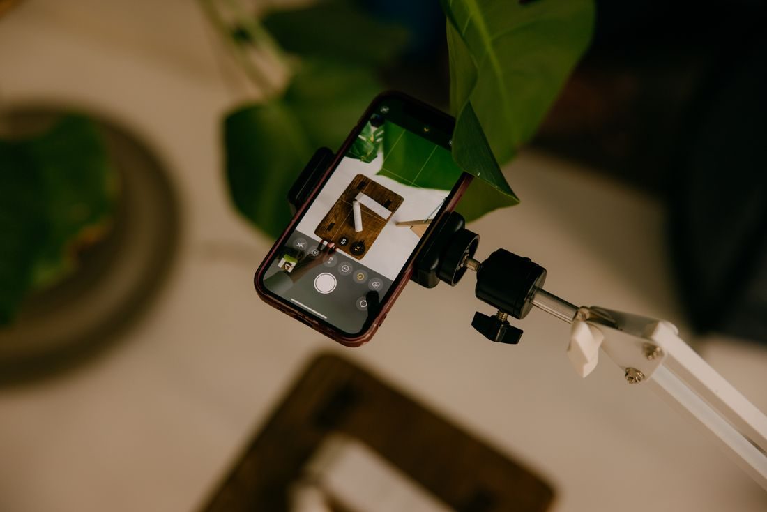 A phone held in a clamp on an adjustable arm.