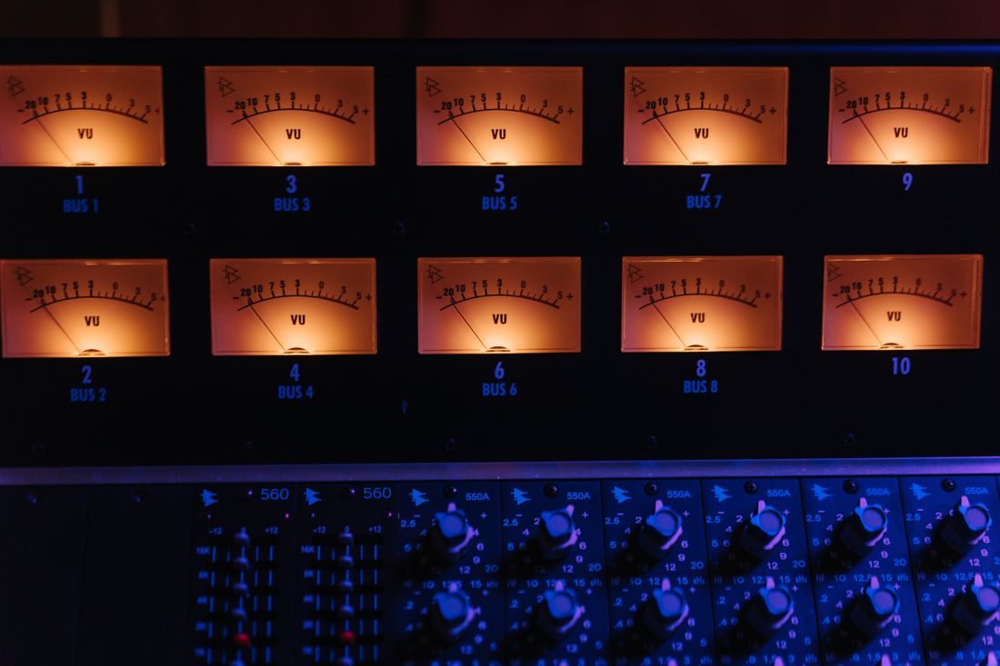 Rows of illuminated analog audio level meters.
