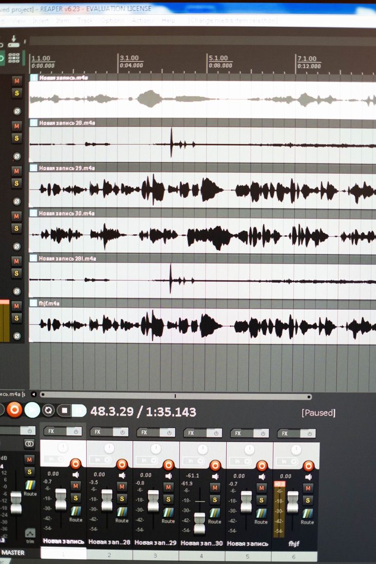 Audio waveforms and channel controls on an editing screen.