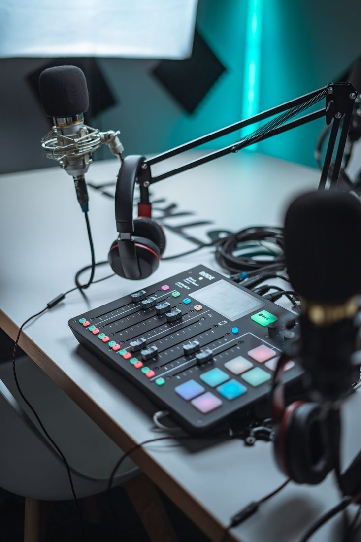 Microphones, headphones and an audio mixer on a studio table.