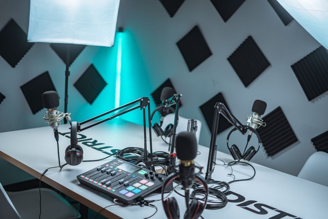 A podcast table with microphones and acoustic panels on the walls.
