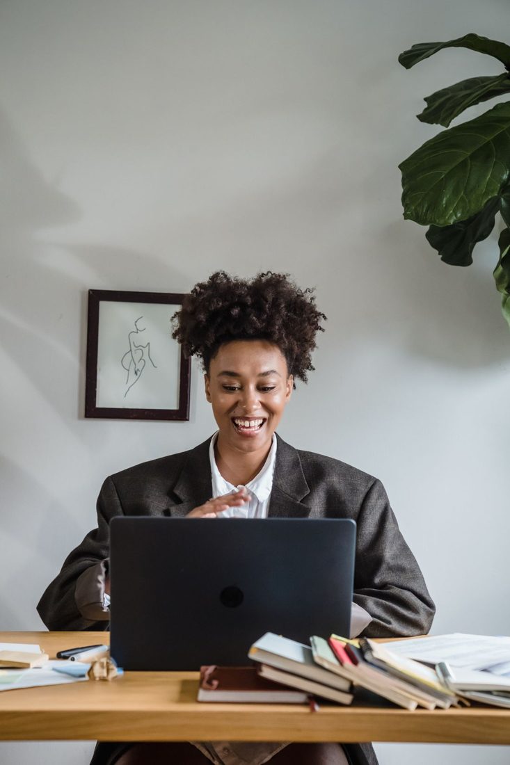 A woman using a laptop at a compact desk.