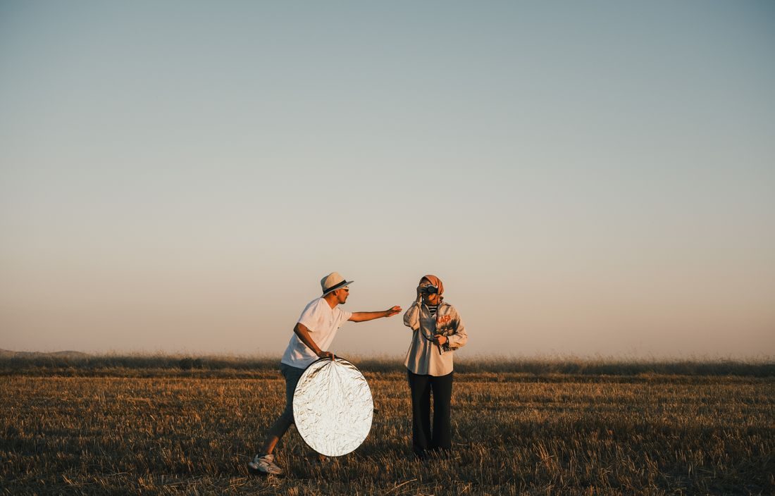 A person holding a circular reflector during an outdoor portrait.
