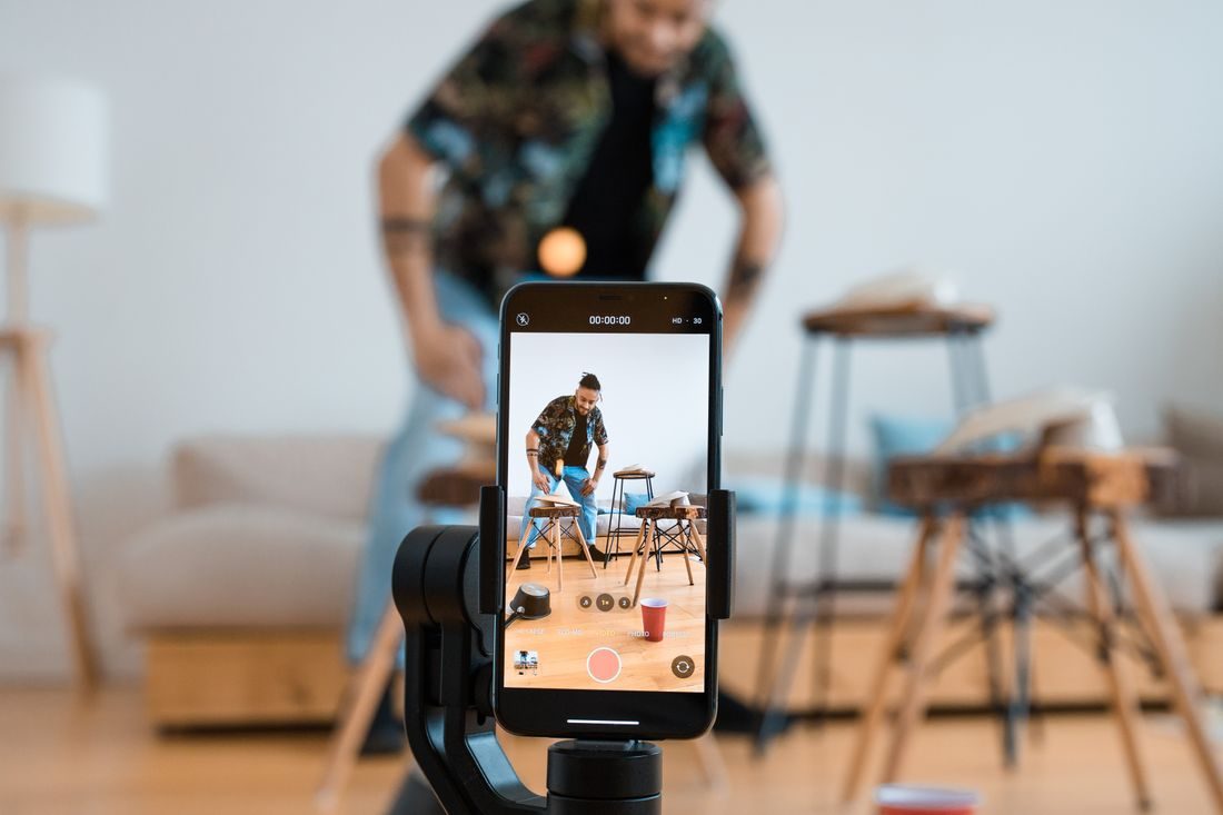 A phone recording a man exercising in a living room.