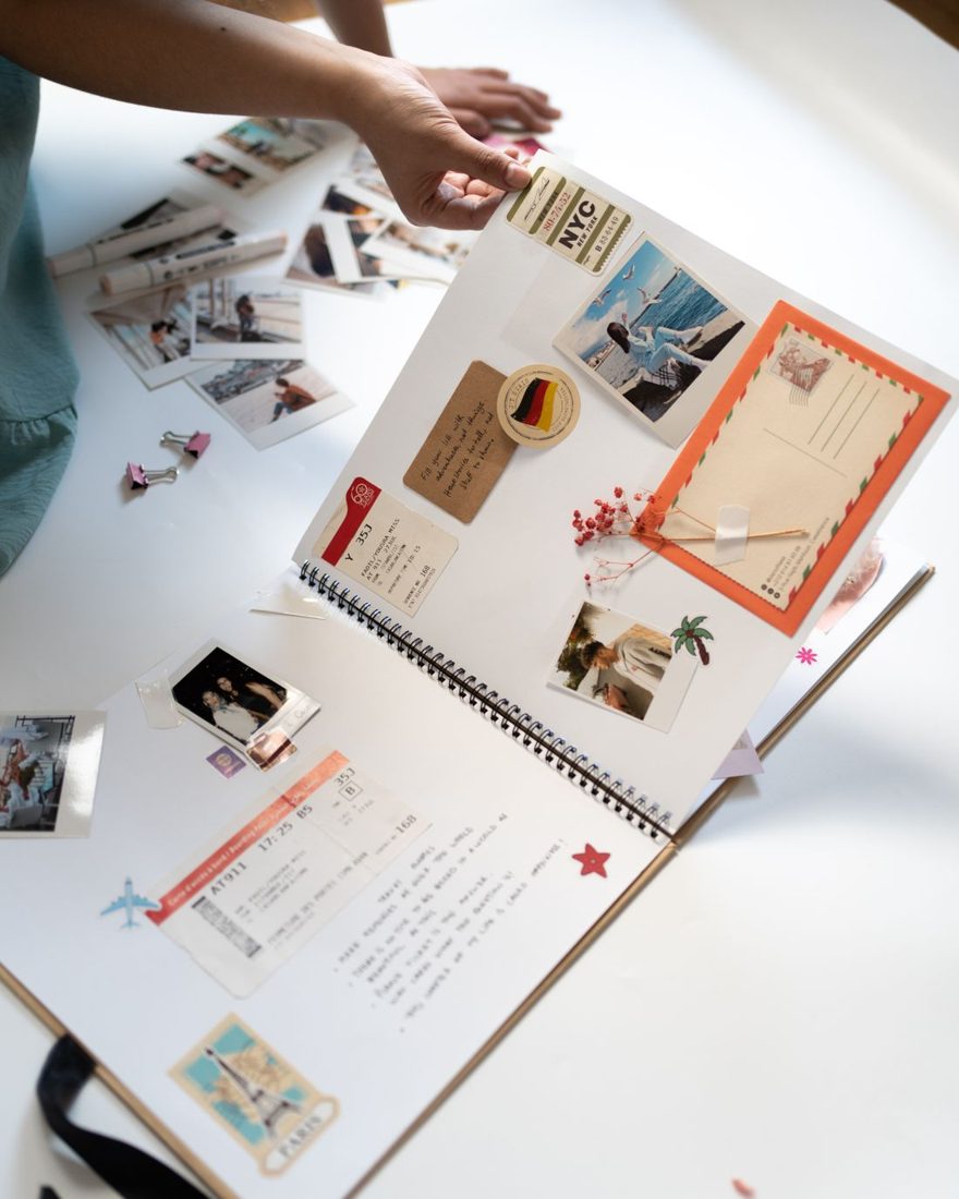 A scrapbook with photographs, postcards and handwritten notes.