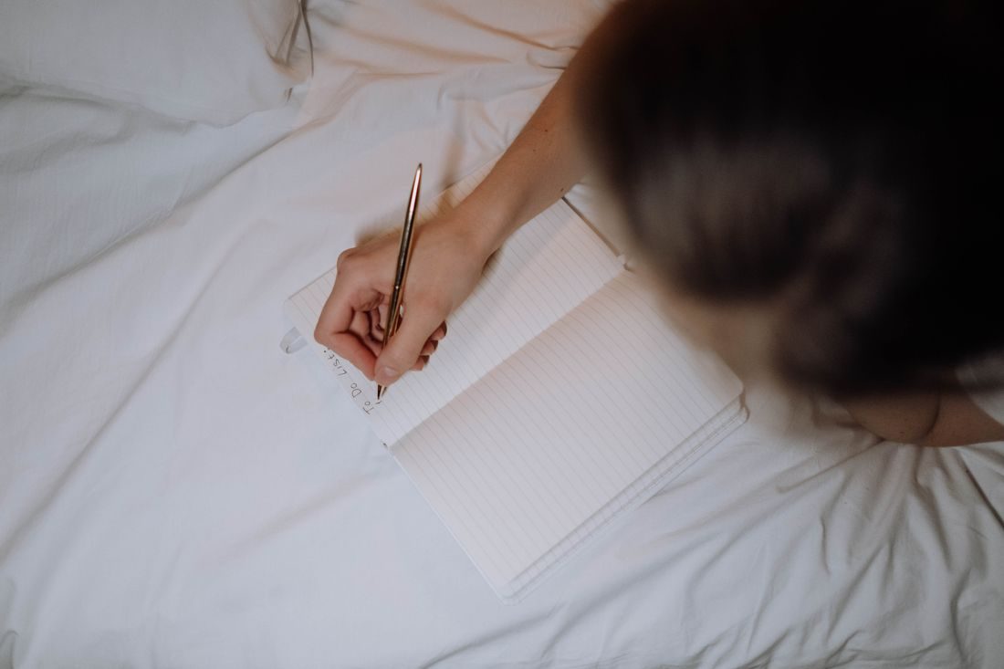 A person writing a list in a notebook.
