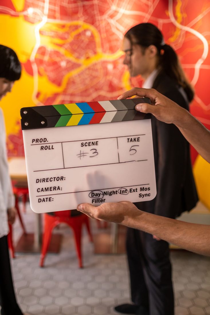 A person holding a clapperboard on a film set.