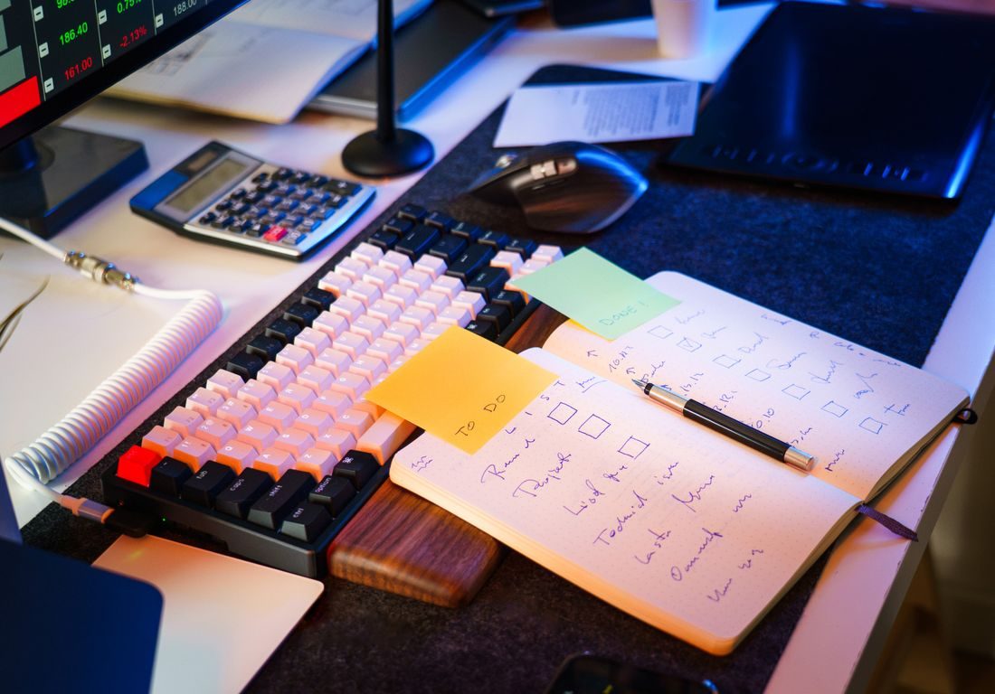 An open planner and notes beside a keyboard.